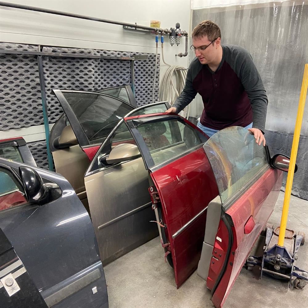  EMCC student Douglas Maxwell looks through the car doors his class collected from Wilbert's.